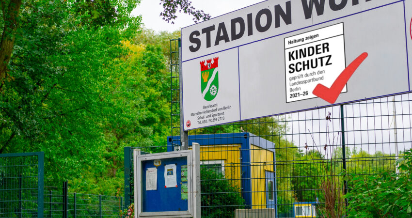 Das Schild vom Stadion Wuhletal mit dem eingebauten Kinderschutz Logo.